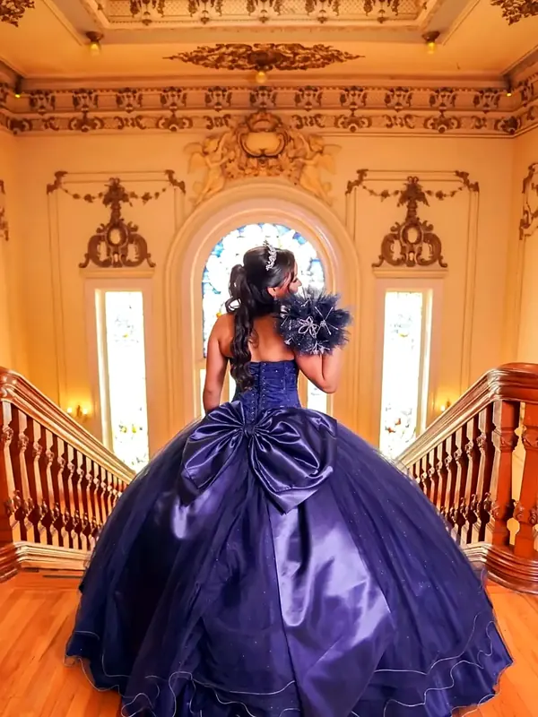 Vestido de XV años morado tipo princesa con gran moño, en salón histórico