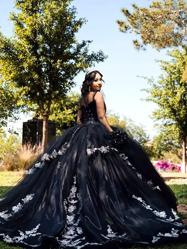 Vestido de XV años negro de tul con bordados blancos y gran cola